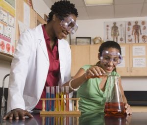 Science teacher assisting teenage girl with science experiment (Photo by Thinkstock)
